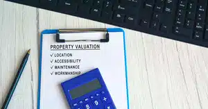 Document on clipboard with text showing property valuation affecting valuation