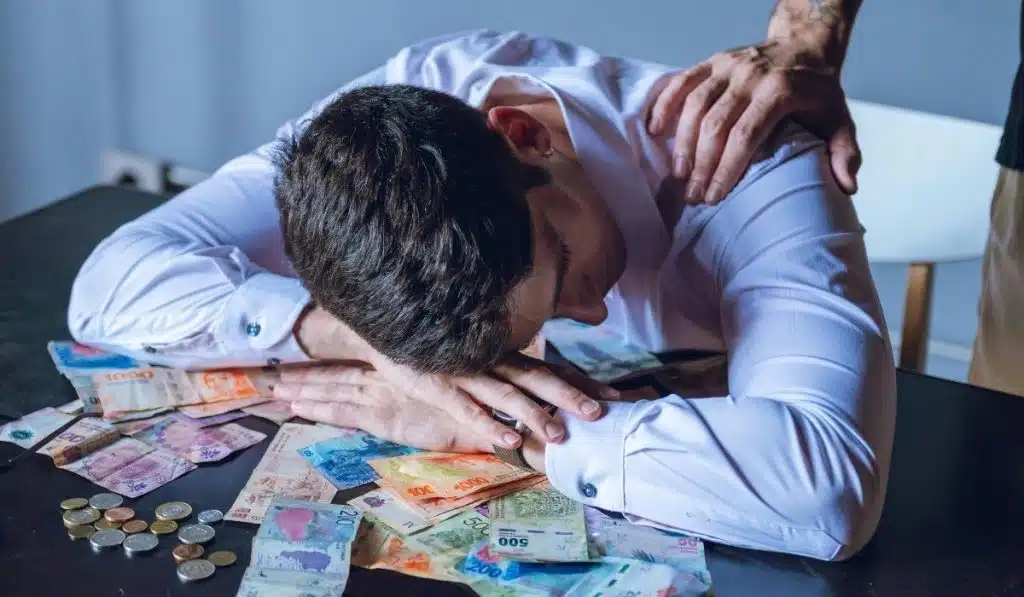 Person stressed about mortgage arrears with cash and bills