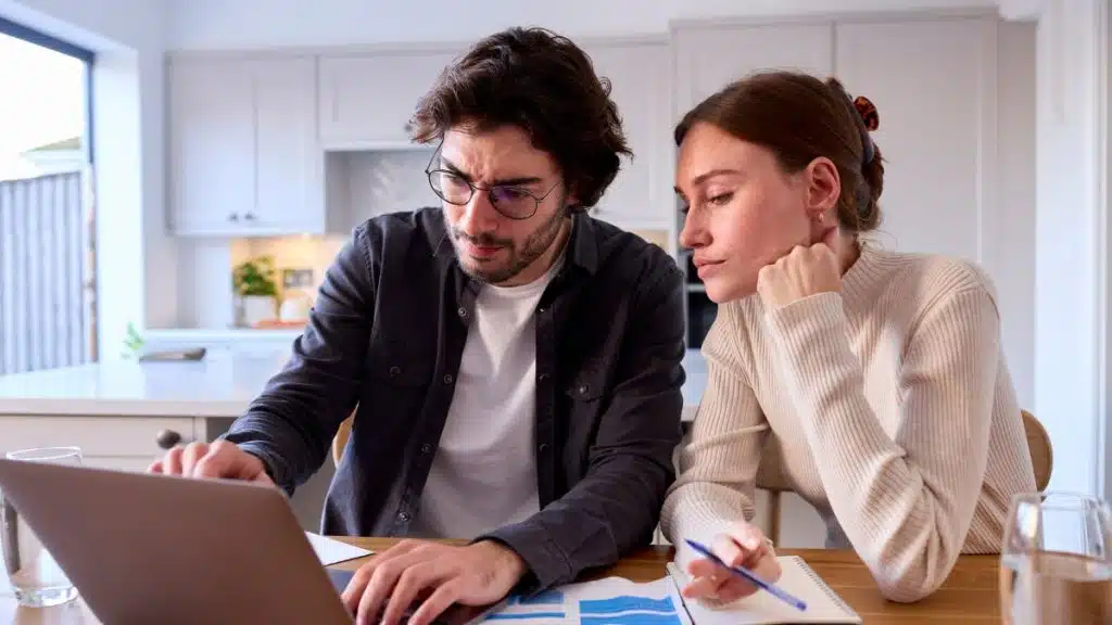 Couple reviewing mortgage paperwork to understand refinance options while behind on repayments in New Zealand