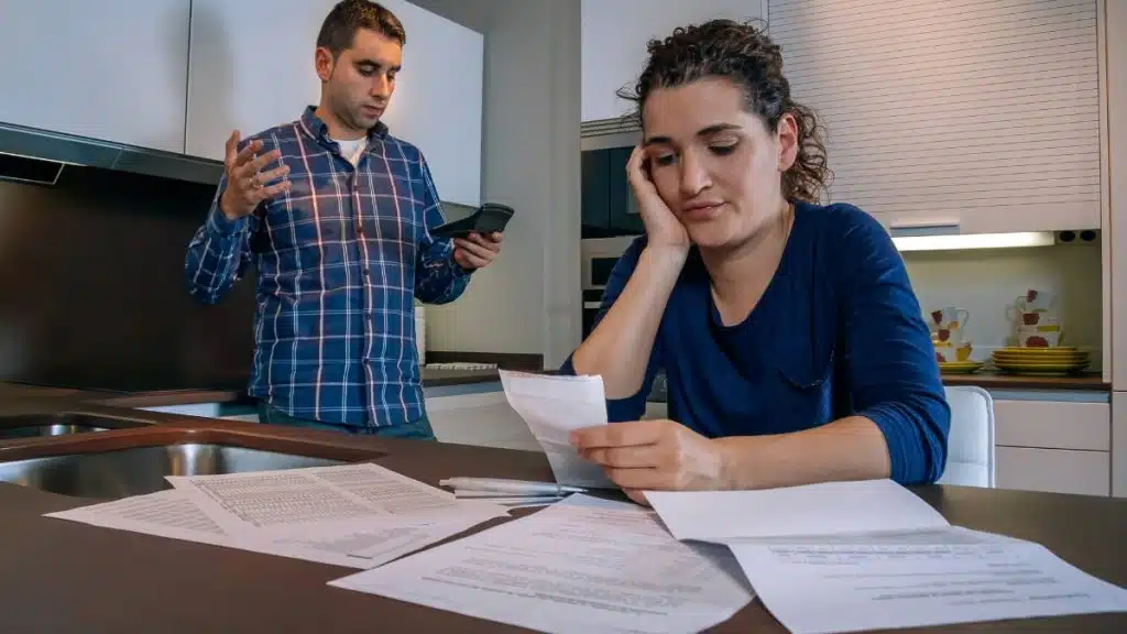 Couple reviewing household bills while trying to catch up on mortgage repayments in New Zealand